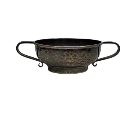 An Edwardian Arts & Crafts silver twin-handled small bowl by A. E. Jones. With hammered decoration, height 2.5cm, width from 