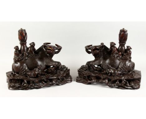 A GOOD PAIR OF 19TH / 20TH CENTURY CHINESE CARVED HARD WOOD BUFFALO FIGURES / LAMPS, the buffalo carved in a recumbent positi