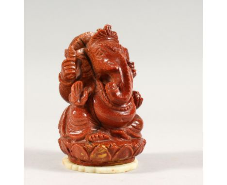 A 20TH CENTURY INDIAN GOLD STONE / GLASS FIGURE OF GANESH, fixed to a carved jade / soapstone pedant, 10cm high.