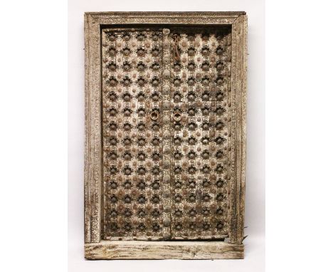 A GOOD PAIR OF 18TH / 19TH CENTURY INDIAN MUGHAL HEAVILY CARVED DOORS WITH ORIGINAL WOODEN FRAME, the doors carved in deep re