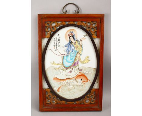 A GOOD CHINESE FAMILLE ROSE FRAMED PORCELAIN PANEL OF GUANYIN, depicted riding upon the back of a carp, with calligraphy to t