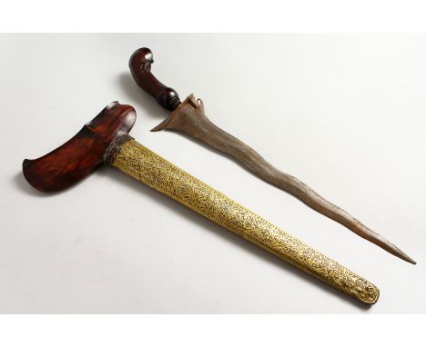 A GOOD 19TH CENTURY INDONESIAN KRIS DAGGER, with a chased brass scabbard, and a carved hardwood hilt, 49cm overall.