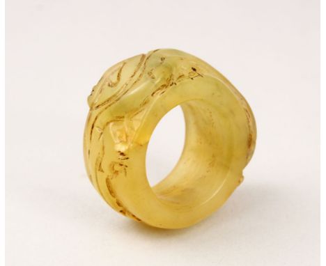 A GOOD CHINESE CARVED HARD STONE / JADE LIKE ARCHERS RING, with carved decoration, 4.5cm.