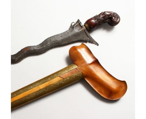 A GOOD 19TH CENTURY INDONESIAN KRIS DAGGER, with an olive wood and chased brass scabbard, and a carved hardwood hilt, 49cm ov