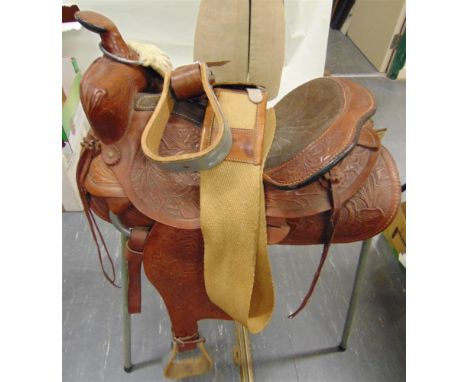 A WESTERN SADDLE with stirrups, together with a jute roller and a tubular saddle rack