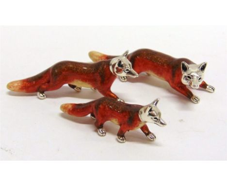 A GRADUATED SET OF THREE SATURNO SILVER AND ENAMEL FOXES,  the largest approx 8cm long
