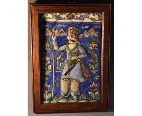 A Persian rectangular tile, decorated in the Iznik palette with a warrior in a stylized landscape, 22.5cm x 14.5cm, 19th cent