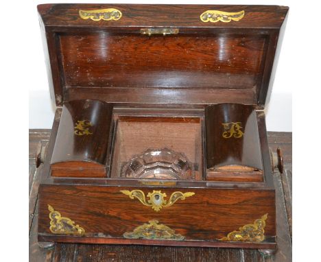 A rosewood sarcophagus shaped tea caddy inlaid with brass and mother of pearl.