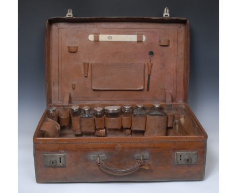 A 19th century leather rectangular travelling vanity case, the interior fitted with clear facetted jars, with silver covers, 