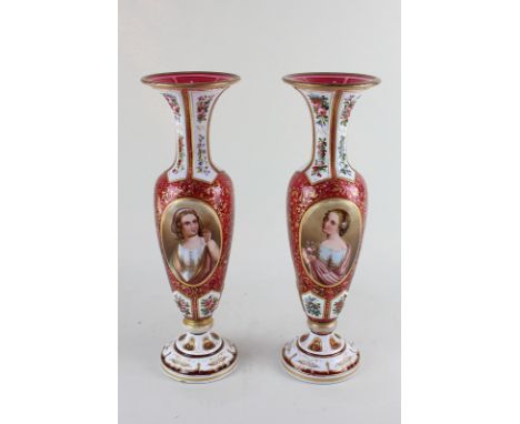 A pair of 19th century Bohemian cranberry glass baluster vases, each with enamelled portrait panel of a young girl with gilt 