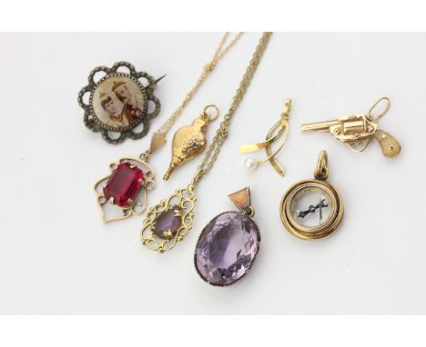 An 18ct compass pendant, gold revolver charm, bellows charm, an amethyst pendant, a red stone pendant on chain, a pearl penda