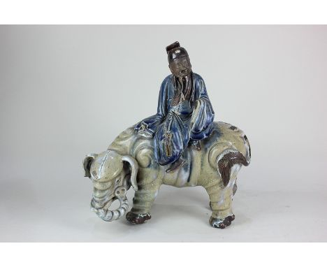 A Chinese glazed ceramic figure group, in the form of a sage atop an elephant, 33cm (a/f)