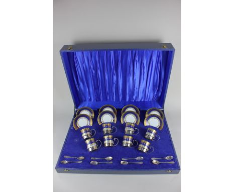 A silver mounted eight piece Rudolf Wachter porcelain coffee set of eight coffee cans with silver cup holders, saucers and ei