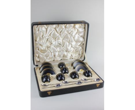 An early 20th century cased Royal Worcester porcelain six-piece coffee set of six cups and saucers in black with gilt Greek k