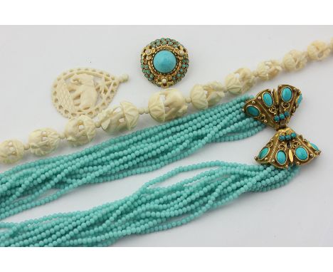 A blue glass bead necklace with gilt clasp and matching brooch, and a carved ivory necklace and pendant