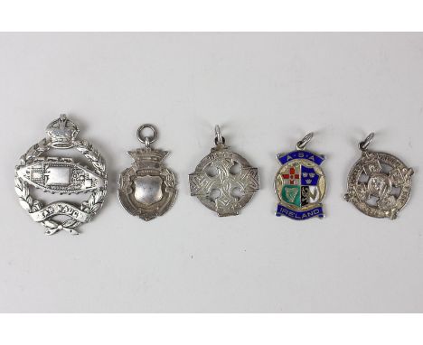 A Royal Tank Regiment Officers cap badge (worn), three Irish silver pendant medallions and a silver badge