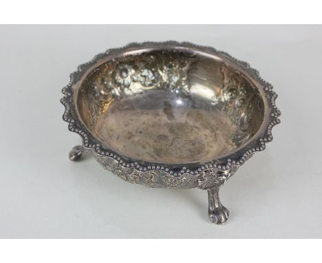 A Victorian silver circular bowl with shaped beaded border, embossed floral decoration, on three mask paw feet, maker William