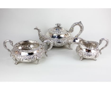 A William IV Irish silver three piece tea  set of squat circular form with well chased floral bands, spout and loop handle, w