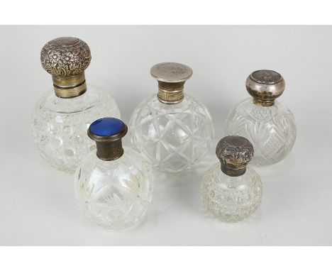 Five various cut glass globular scent bottles including four with silver tops and another with gilt metal and blue enamel top