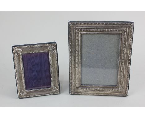 A modern silver photograph frame, rectangular shape with decorative border, blue cloth backing and easel stand, 18cm high, an