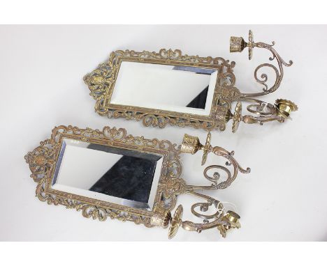 A pair of gilt metal girondelle wall mirrors, each with scrolling pierced frame, and two light candle holders, mirror plates 