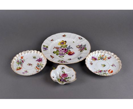 A small assortment of Dresden porcelain, comprising a plate, four large saucers and a leaf shaped dish, all with floral decor