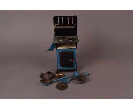 A tinplate miniature model gas cooker, c.1930, complete with pots and pans, ladle, etc.  25.5 cm H 