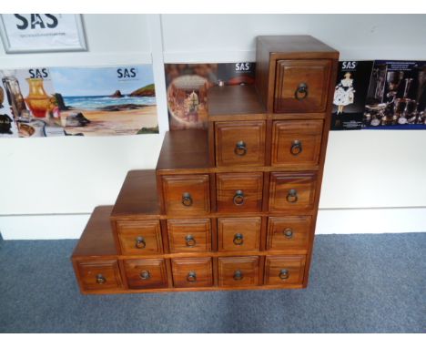 A modern Indonesian hardwood step cabinet, made up of banks of square drawers 95 cm H 