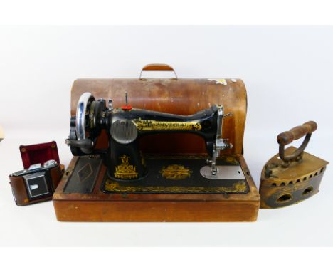 A mid 20th century Singer sewing machine with gilt Sphinx decoration, serial number EJ401385, in carrying case, also included