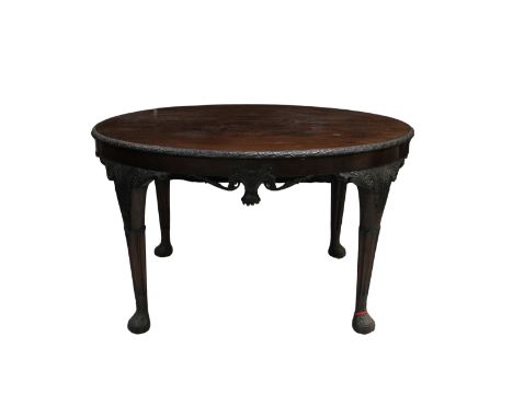 A 19th century Irish Chippendale style mahogany circular table with carved frieze, raised on four foliate carved shaped cabri