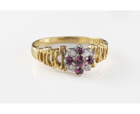 An 18ct yellow gold ruby and diamond ring having 5 round cut rubies in a cross formation, with four round cut diamonds to cor