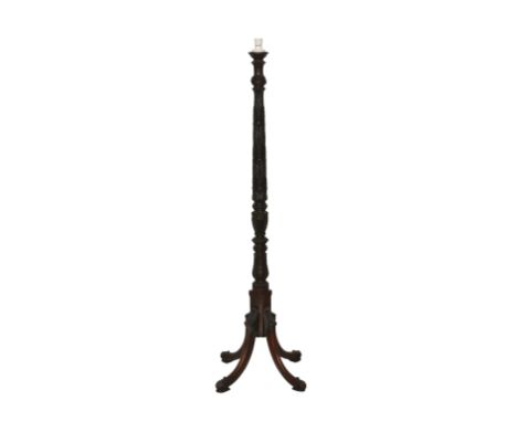 A George III style mahogany standard lamp 1920's, the heavily carved column on four swept legs terminating in scroll carved p