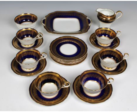 An elegant cobalt blue and gilded Aynsley part tea service comprising serving plate, sugar bowl, jug, six tea cups and saucer