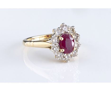 A 9ct yellow gold ruby and diamond cluster ring the oval cut ruby approx 1.00ct, within a border of round brilliant cut diamo