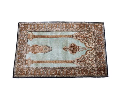 Three part-silk prayer rugs the first on blue ground with a hanging lantern and twin columns to the Mihrab, vine spandrels an