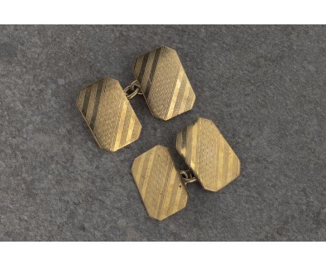 A pair of 9ct gold cufflinks of rectangular form, with engine-turned decoration, loose chain. * 5.6g