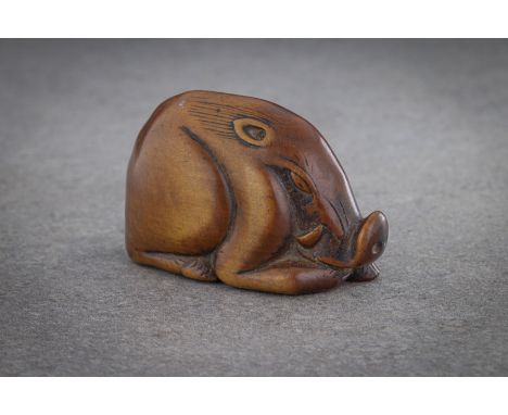 A WOOD NETSUKE OF A RECUMBENT BOAR Unsigned, probably 19th century carved as a boar resting, its head lowered, the eyes close