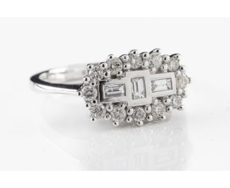 An 18ct white gold and diamond boat-head cluster ring set with three baguette cut diamonds within a border of round brilliant