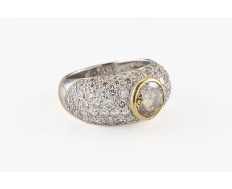 An 18ct white gold and diamond dress ring the central round brilliant cut champagne diamond, approx 1.25cts, in a yellow gold