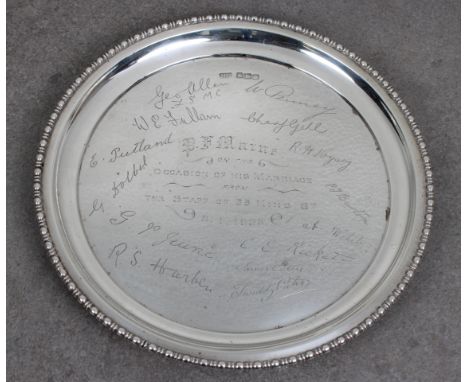 A presentation silver card waiter Atkin Brothers, Sheffield, 1922, of typical form with beaded rim, raised on three feet, eng