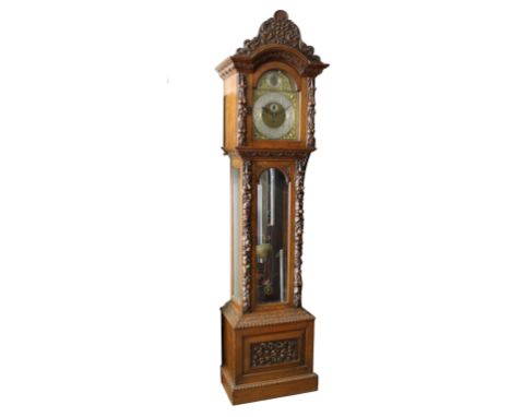 An English, late 19th century, elaborately carved oak musical three train long case clock the brass arched dial with a silver