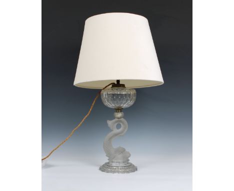 An early 20th century clear glass dolphin oil lamp comprising a cut glass reservoir supported by a frosted glass stem in the 