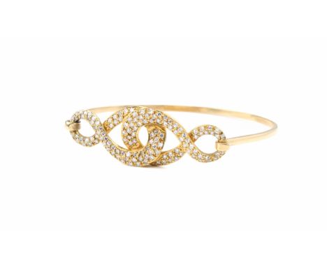 An 18ct yellow gold and diamond bangle unmarked, tests as 18ct gold, the open, interlaced scrollwork setting pavé set with br