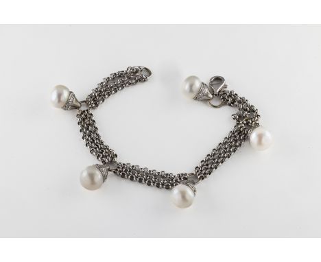 An 18ct white gold pearl and diamond bracelet the triple row belcher chain suspending five button pearls, mounted in diamond 