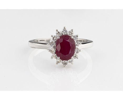 An 18ct white gold ruby and diamond cluster ring the oval cut ruby approx 1.93cts, surrounded by round brilliant cut diamonds