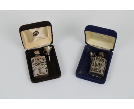 Two silver cased glass perfume bottles each accompanied by a silver funnel, 2¼in. (5.7cm.) and 2½in. (6.3cm.). high. (2) * Go