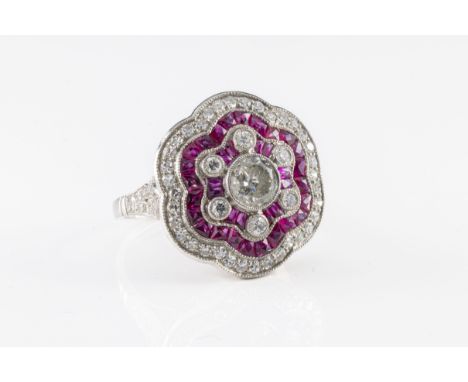 A platinum, ruby and diamond flowerhead cluster ring the central transitional cut diamond weighing 0.80ct, surrounded by thir
