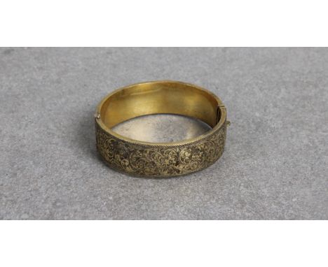 A silver gilt bangle Smith &amp; Pepper Ltd, Birmingham, 1934, push clip fastening, one half plain, the other having bright c