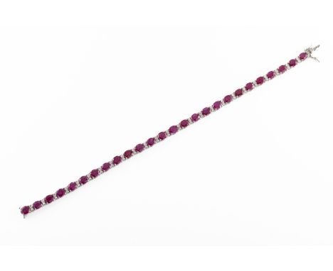 An 18ct white gold ruby and diamond line bracelet the oval cut rubies approx 11.7cts, divided by round brilliant cut diamonds