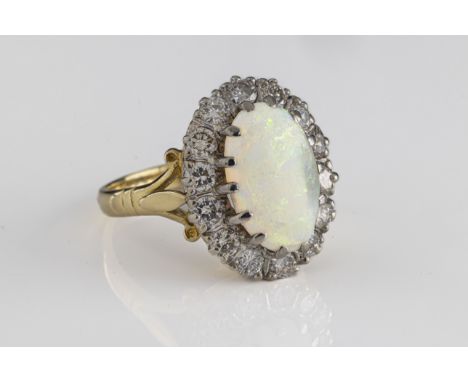 An 18ct yellow gold opal and diamond cluster ring set with an oval cabochon opal approx 2.25cts, within a border of round bri